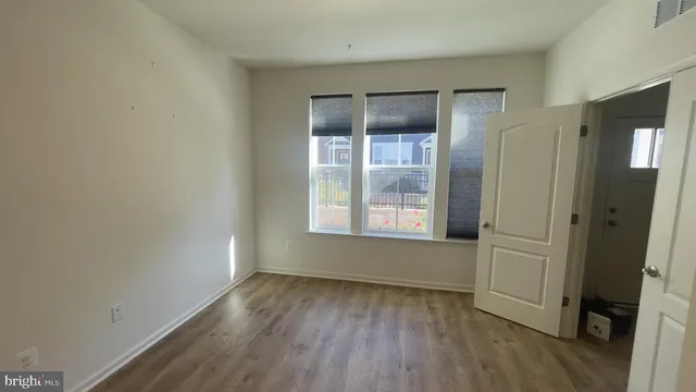 an empty room with wooden floor and a window
