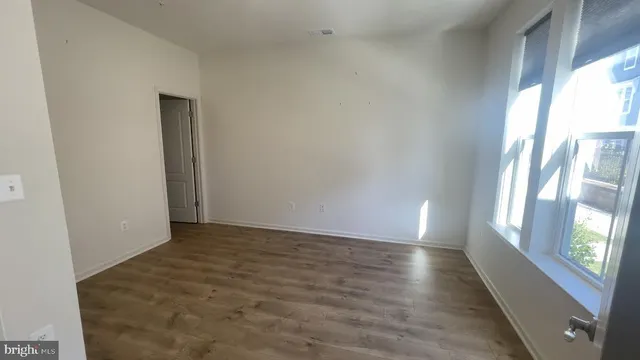 a view of an empty room with glass door and windows
