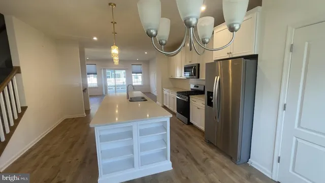 a kitchen with stainless steel appliances granite countertop a refrigerator a oven and a sink with large mirror