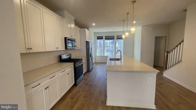 a kitchen with kitchen island a stove a sink a refrigerator and a microwave