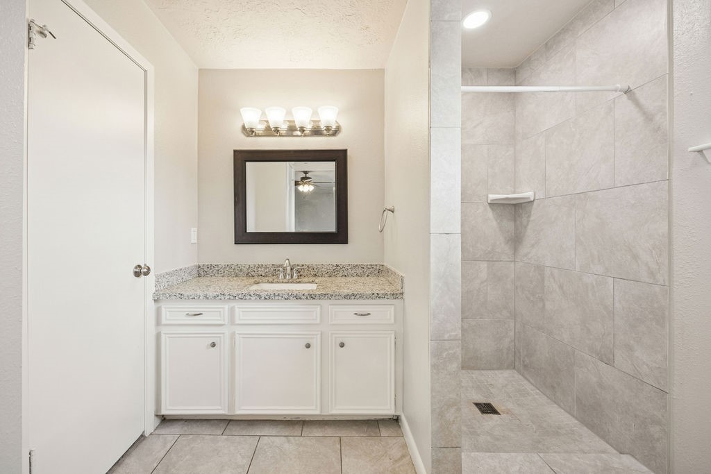 4019 Danpree Street Pasadena, TX 77504 - Photo 14 of 20 a bathroom with a granite countertop sink a mirror and a shower