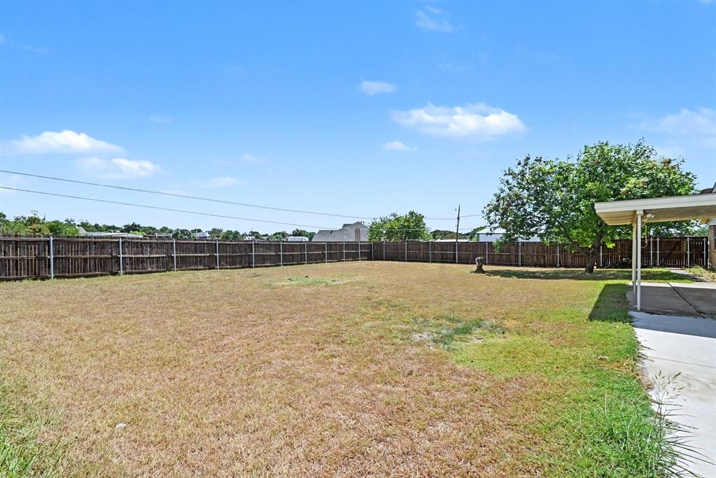 332 Cook Road Willow Park, TX 76087 - Photo 25 of 26 Expansive backyard featuring a full privacy fence, mature trees, and a covered patio area