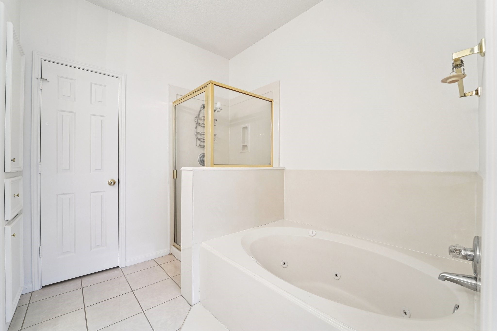 14420 Walters Road, Unit 55 Houston, TX 77014 - Photo 26 of 35 This bathroom features a spacious layout with a luxurious jetted tub, a separate glass-enclosed shower, and bright white tile flooring.