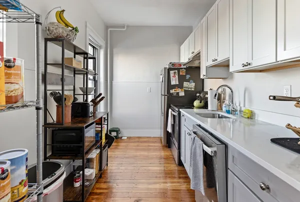 a kitchen with stainless steel appliances a sink stove and cabinets