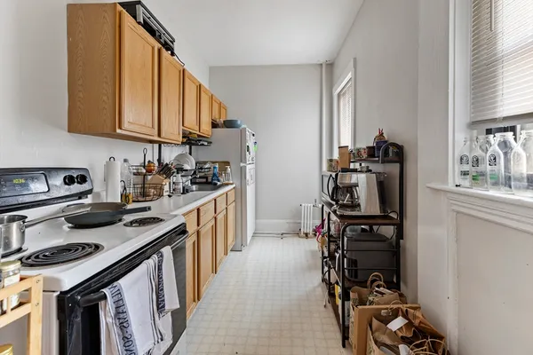 a kitchen with a sink appliances cabinets and a window