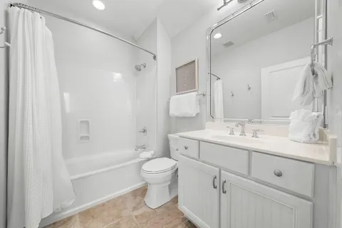 a bathroom with a double vanity sink toilet mirror and shower