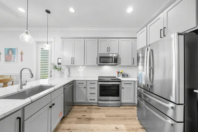 a kitchen with stainless steel appliances granite countertop a sink stove and refrigerator