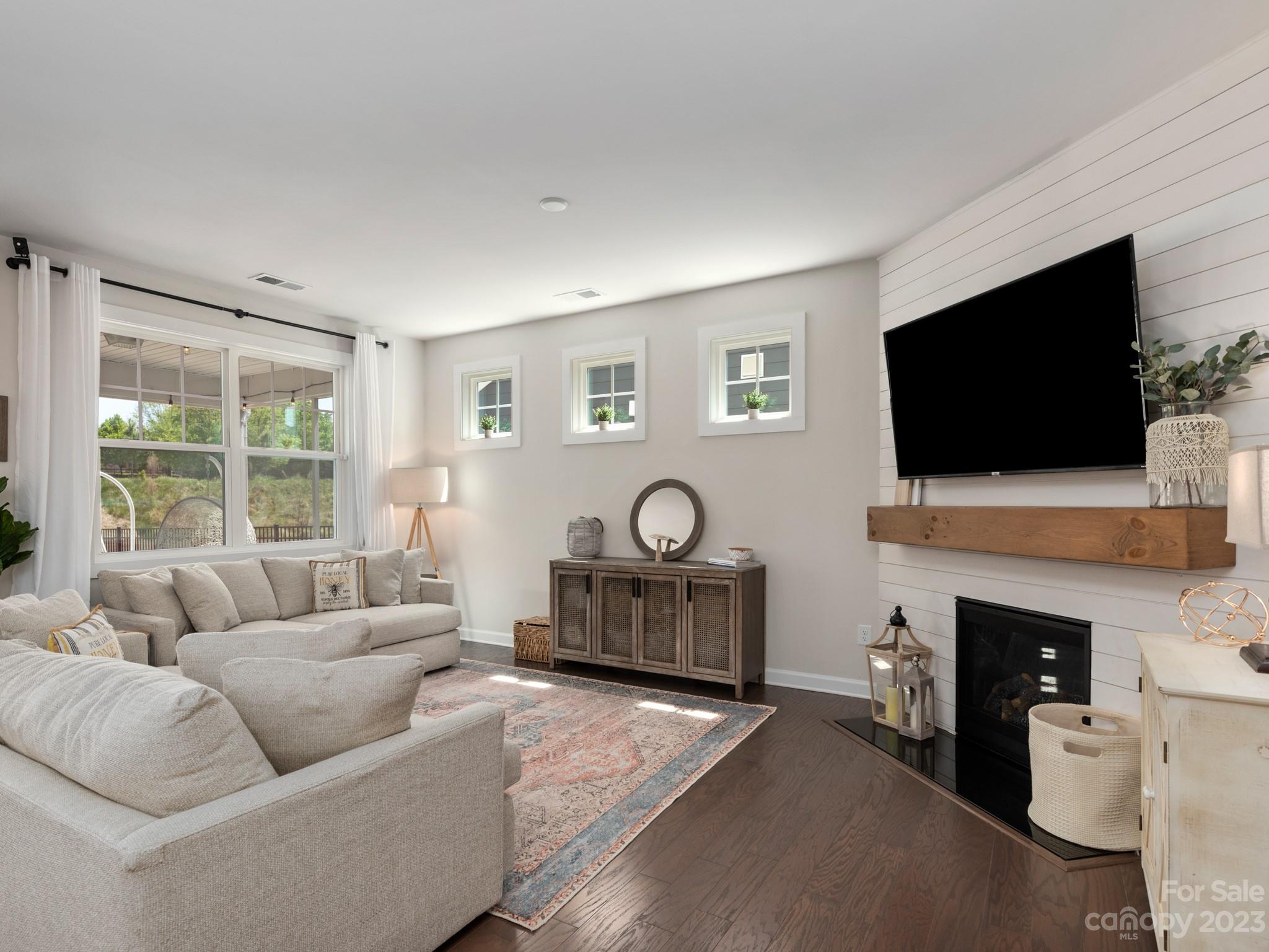413 Hudson Place Davidson, NC 28036 - Photo 11 of 38 a living room with furniture a flat screen tv and a fireplace