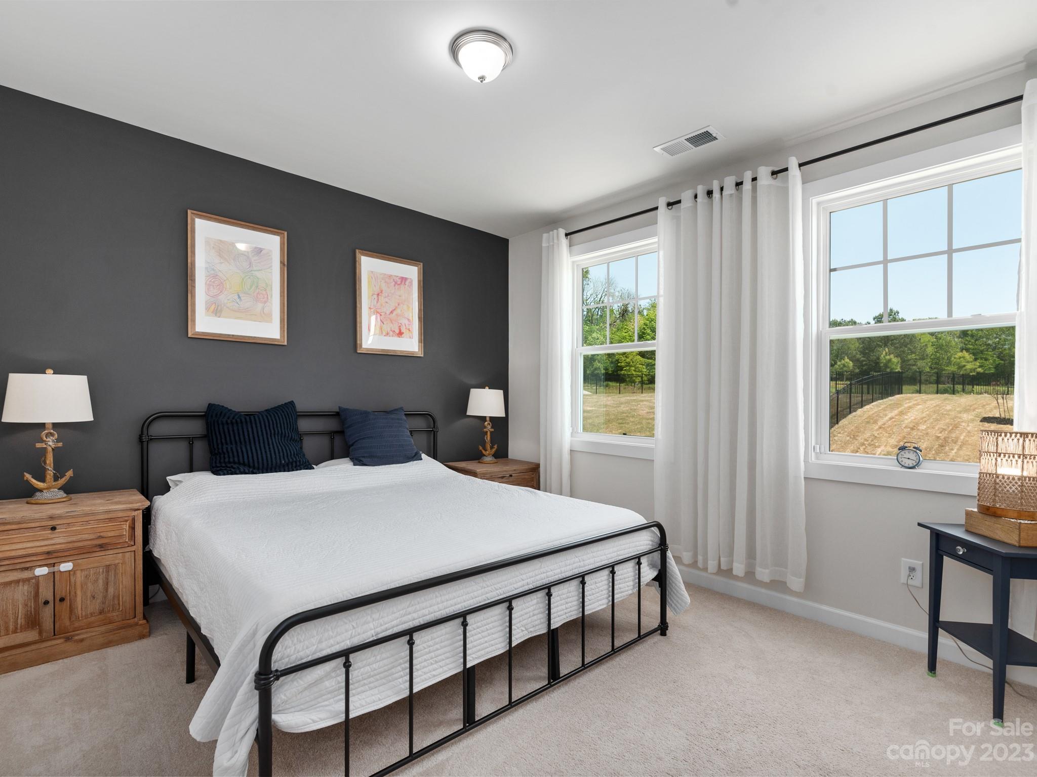 413 Hudson Place Davidson, NC 28036 - Photo 19 of 38 a bedroom with a bed a table and windows