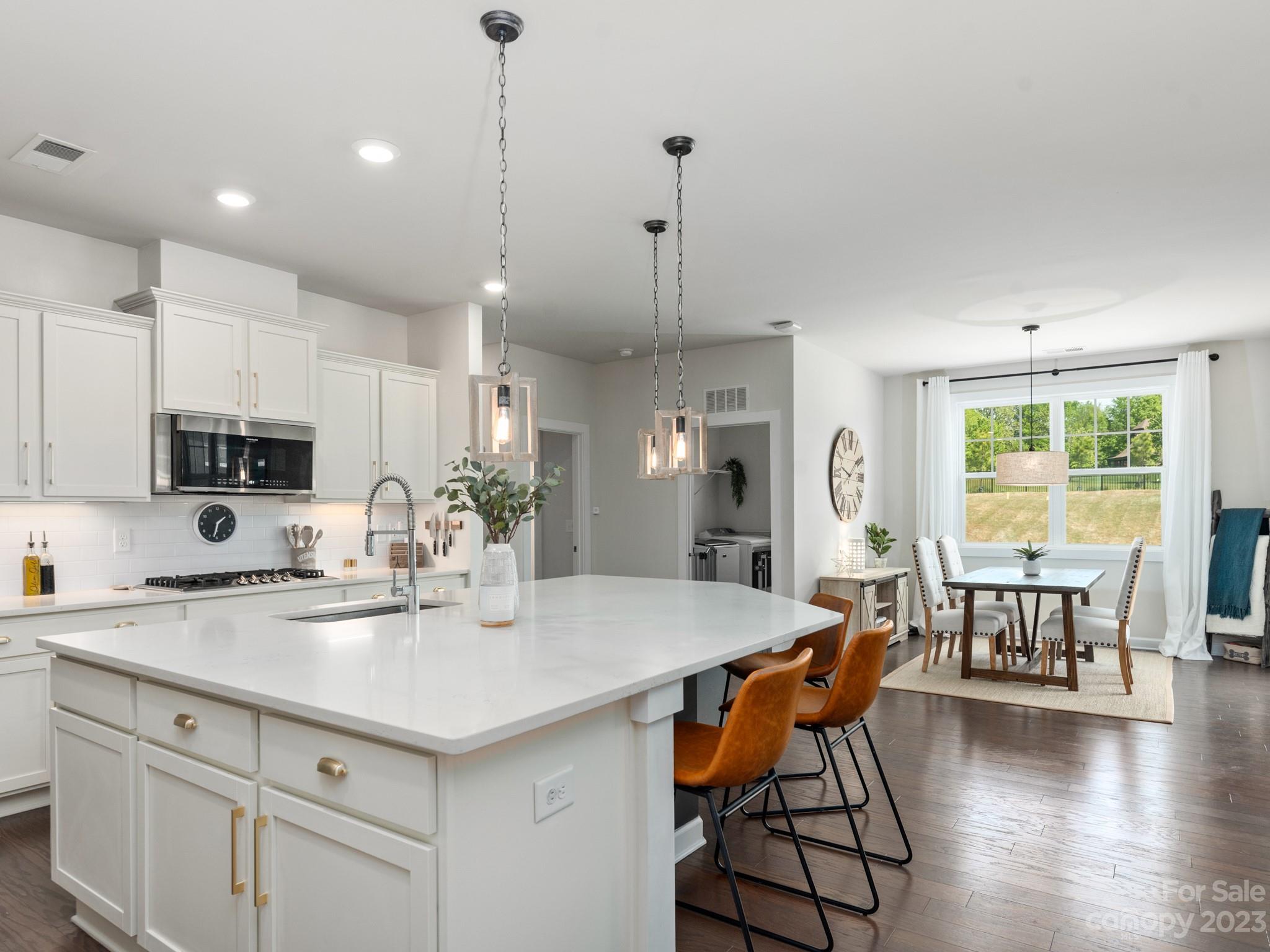 413 Hudson Place Davidson, NC 28036 - Photo 7 of 38 a kitchen with stainless steel appliances granite countertop a kitchen island a stove a table and chairs