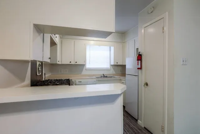 a kitchen with granite countertop a sink cabinets and window