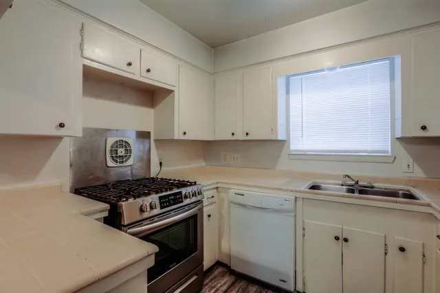 a kitchen with cabinets appliances and a window