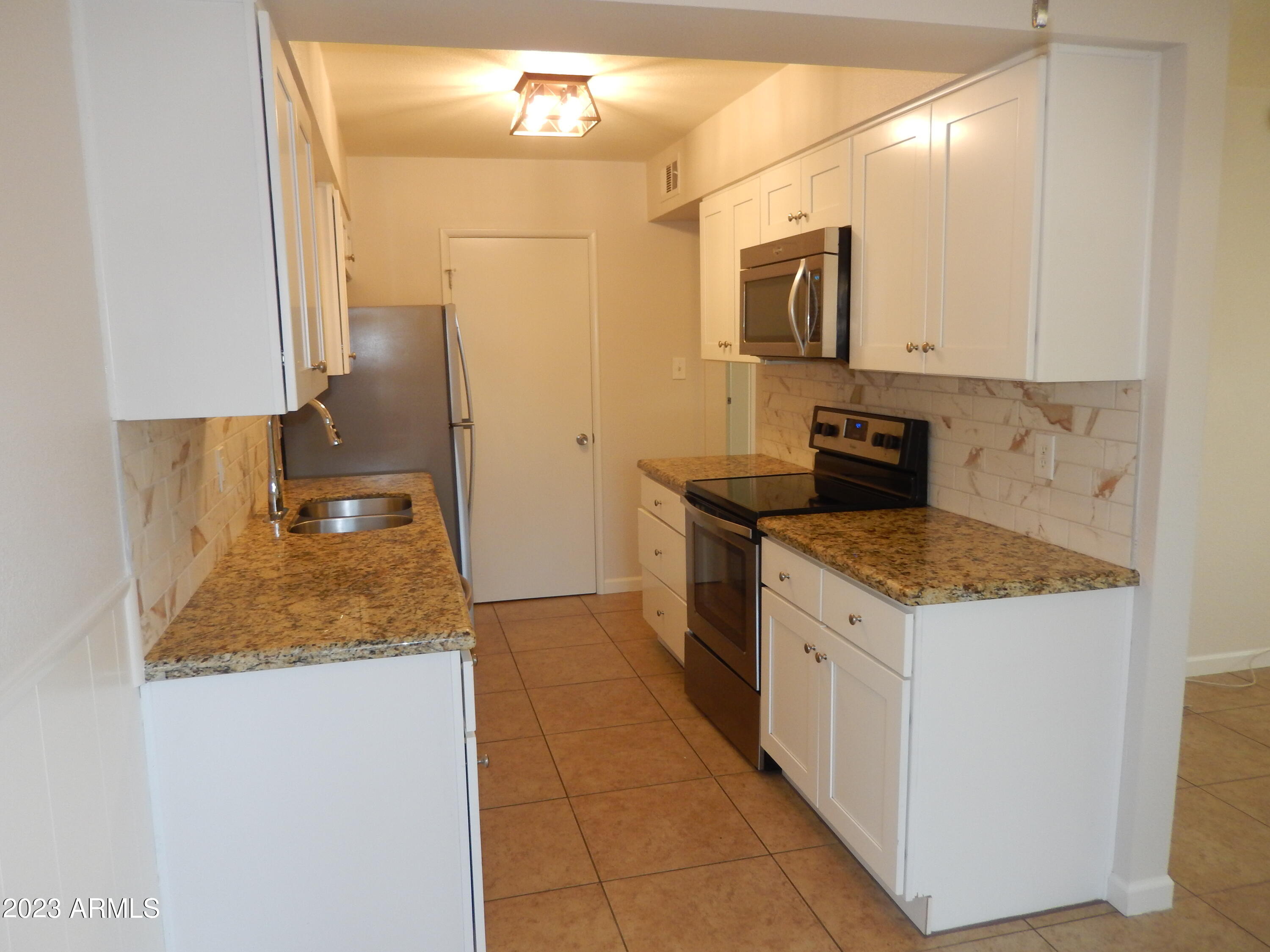 3618 East Montecito Avenue, Unit 2 Phoenix, AZ 85018 - Photo 6 of 17 a kitchen with stainless steel appliances granite countertop a sink and a stove