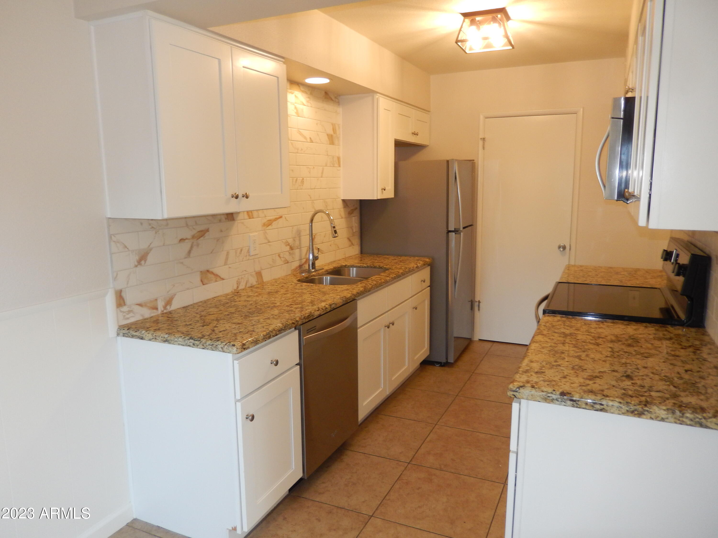 3618 East Montecito Avenue, Unit 2 Phoenix, AZ 85018 - Photo 7 of 17 a kitchen with a sink stove and refrigerator