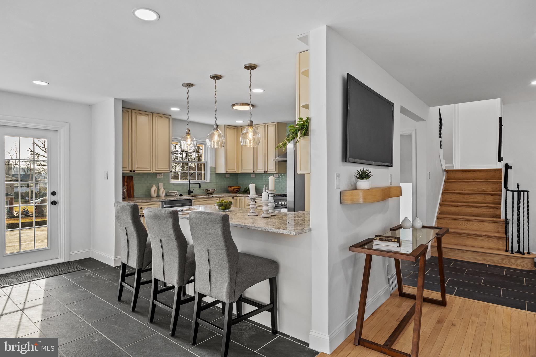 1221 Huntingdon Pike Huntingdon Valley, PA 19006 - Photo 13 of 48 a kitchen with kitchen island a dining table chairs and a refrigerator