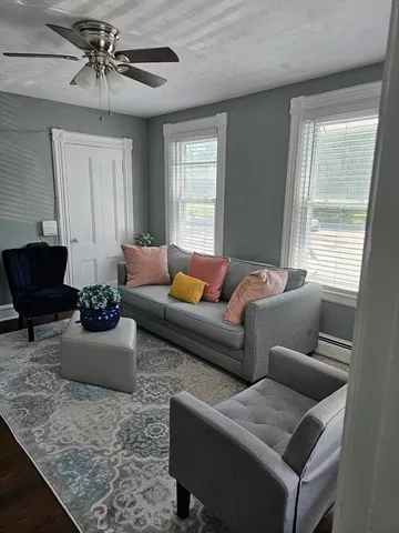 a living room with furniture ceiling fan and a window