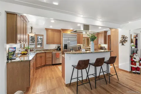a kitchen with stainless steel appliances granite countertop a stove a sink and a refrigerator
