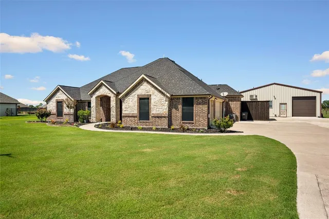 a view of a white house with a big yard and large trees
