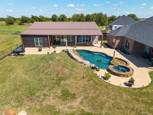 a kitchen with a sink a center island a stove and a wooden floor with living room view