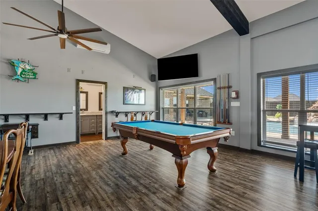 a kitchen with stainless steel appliances kitchen island granite countertop a refrigerator a stove and a sink with wooden floor