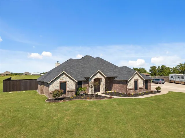 a house with green field in front of it