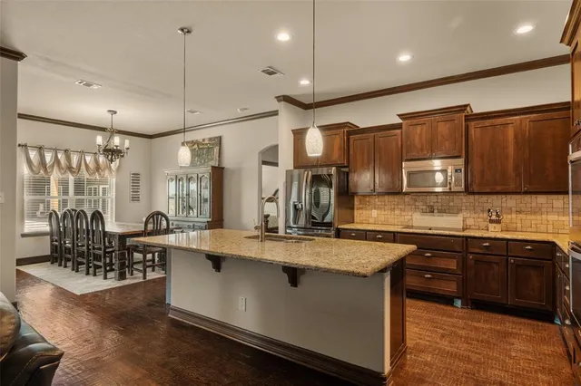 a kitchen with granite countertop a sink and a refrigerator
