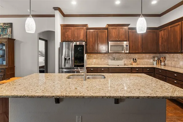a kitchen with a refrigerator a sink and cabinets