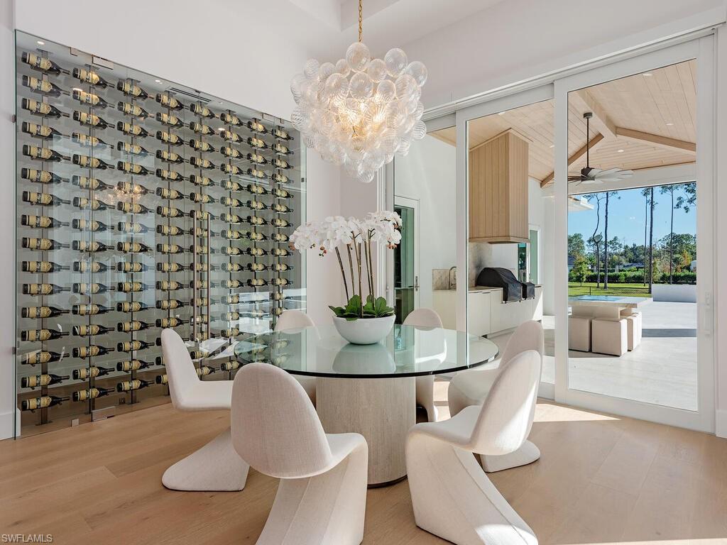 6824 Sable Ridge Lane Naples, FL 34109 - Photo 11 of 36 a dining room with furniture and wooden floor