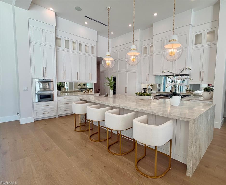 6824 Sable Ridge Lane Naples, FL 34109 - Photo 12 of 36 a room with lots of white furniture and a mirror