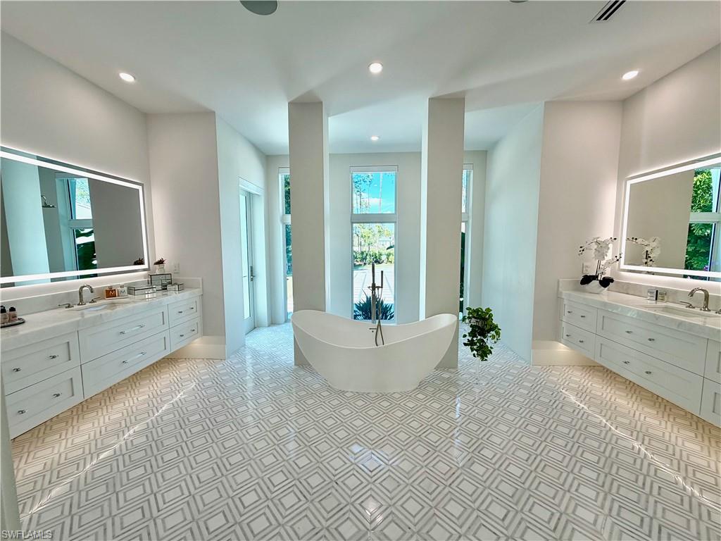 6824 Sable Ridge Lane Naples, FL 34109 - Photo 18 of 36 a large spacious bathroom with a large tub sink and mirror