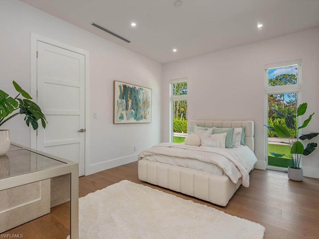 6824 Sable Ridge Lane Naples, FL 34109 - Photo 19 of 36 a bedroom with a bed potted plant and a window