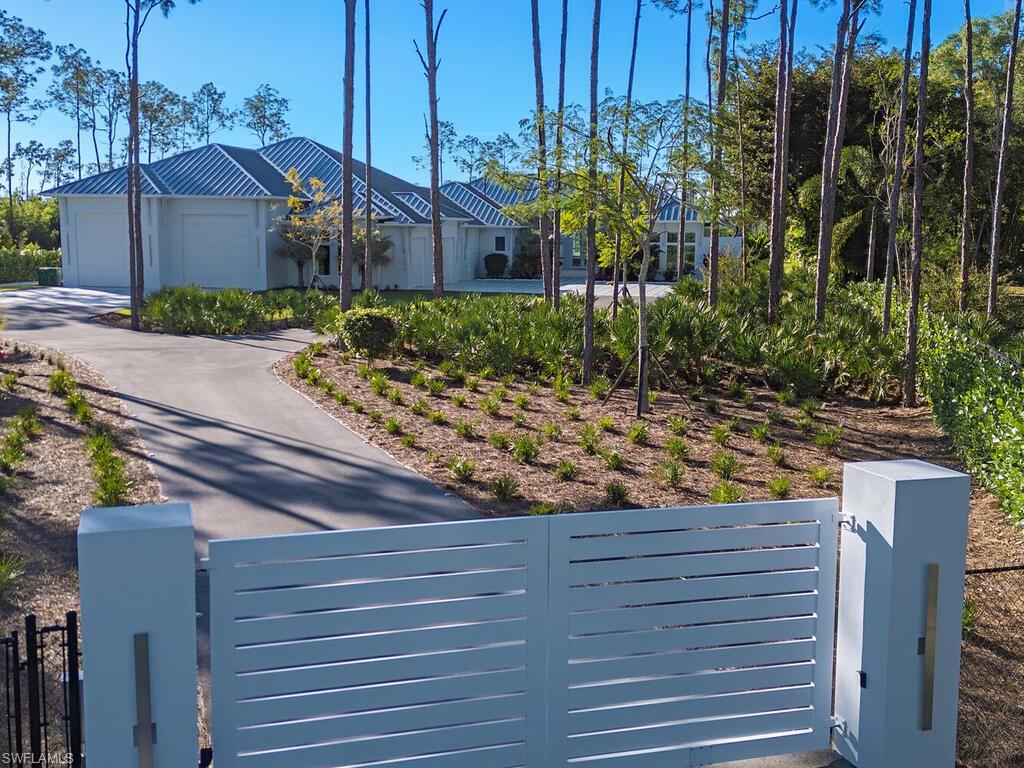 6824 Sable Ridge Lane Naples, FL 34109 - Photo 36 of 36 a view of a wooden house with a yard and large trees