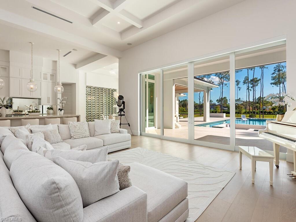 6824 Sable Ridge Lane Naples, FL 34109 - Photo 7 of 36 a living room with furniture and a large window with kitchen view