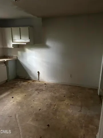 a view of a hallway with wooden floor and a bathroom