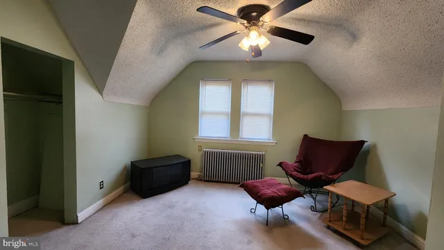 a living room with furniture and a ceiling fan