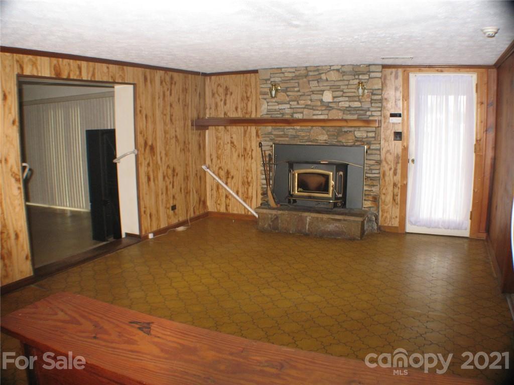 2060 Ridge Road Hendersonville, NC 28792 - Photo 4 of 21 an empty room with wooden floor fireplace and windows