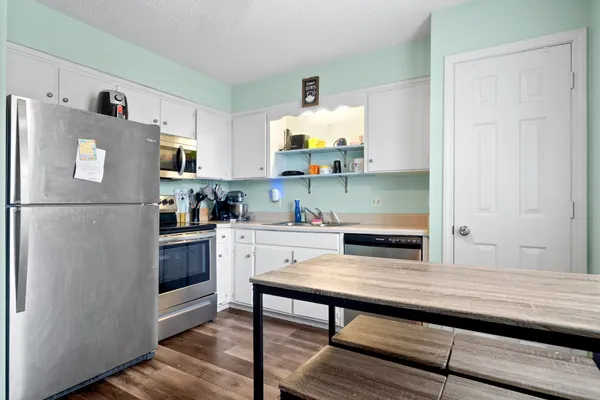 a kitchen with stainless steel appliances granite countertop a refrigerator and a stove top oven