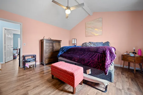 a bedroom with a bed wooden floor and window