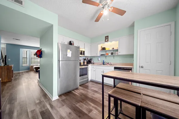 a kitchen view with furniture a refrigerator and a view of living room