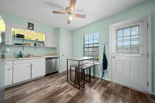 a kitchen with a table chairs sink and cabinets