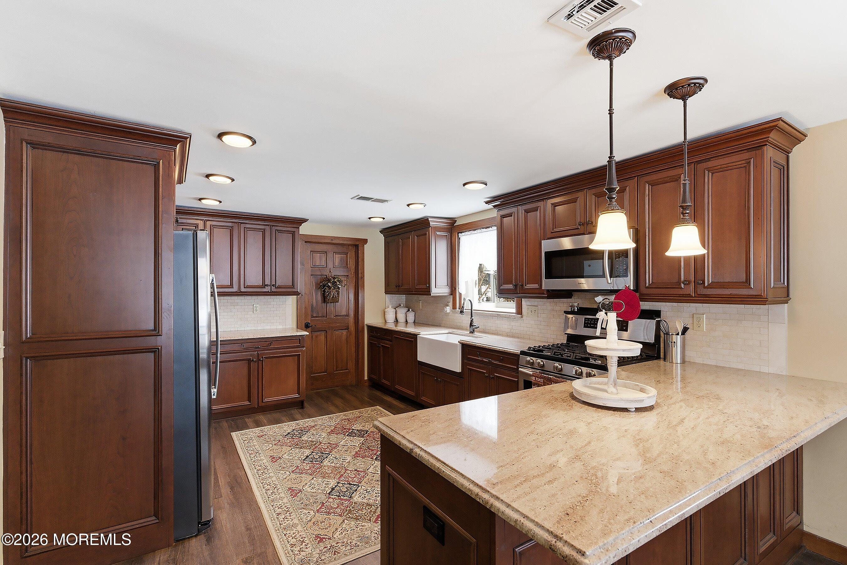 515 Carroll Fox Road Brick, NJ 08724 - Photo 32 of 60 a kitchen with a refrigerator a sink dishwasher a stove and a refrigerator with wooden floor