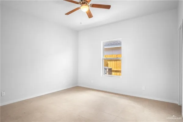 an empty room with a window and a fan