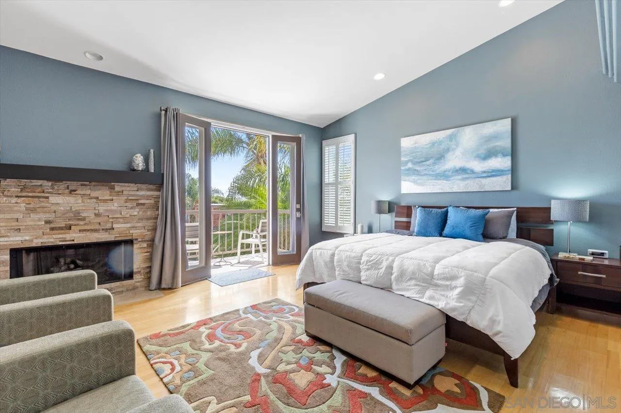 312 Bonair Street La Jolla, CA 92037 - Photo 14 of 40 a bedroom with a large bed and a fireplace