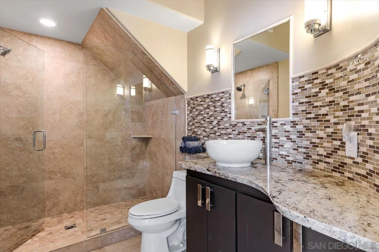 312 Bonair Street La Jolla, CA 92037 - Photo 23 of 40 a bathroom with a granite countertop sink a toilet and shower