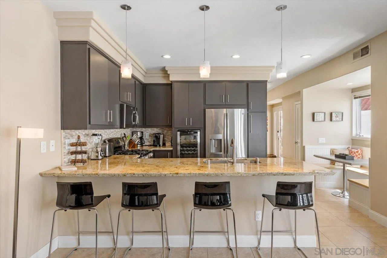 312 Bonair Street La Jolla, CA 92037 - Photo 10 of 40 a kitchen with stainless steel appliances kitchen island granite countertop a sink and cabinets