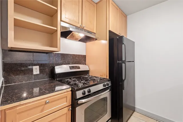 a kitchen with stainless steel appliances granite countertop a refrigerator and a stove