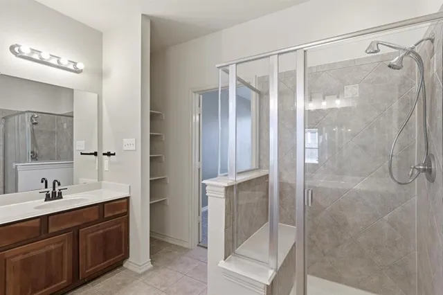 a bathroom with a shower sink and mirror