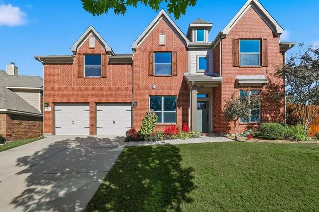 a front view of a house with a yard and trees