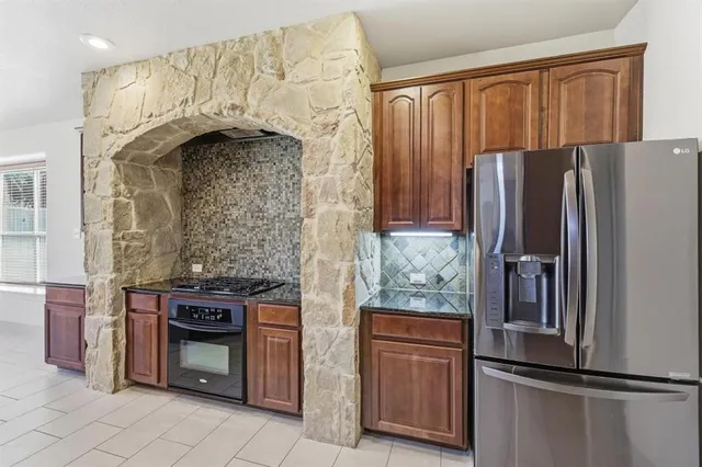 a kitchen with stainless steel appliances granite countertop a refrigerator and a stove
