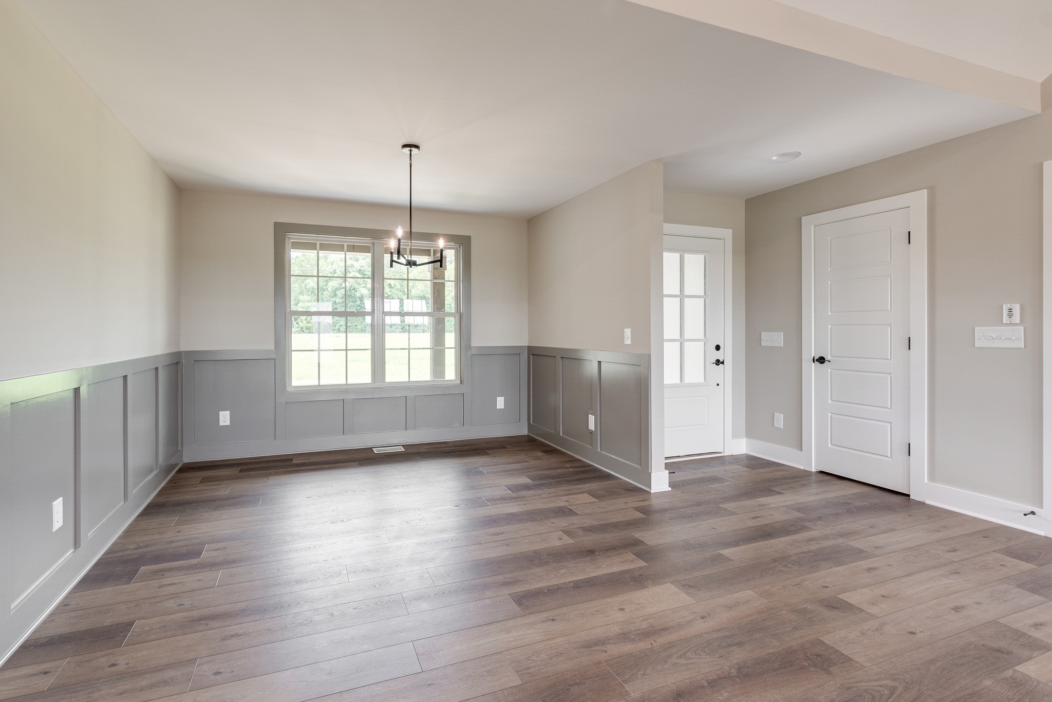 928 Butler Bridge Road Portland, TN 37148 - Photo 14 of 26 an empty room with wooden floor chandelier and windows